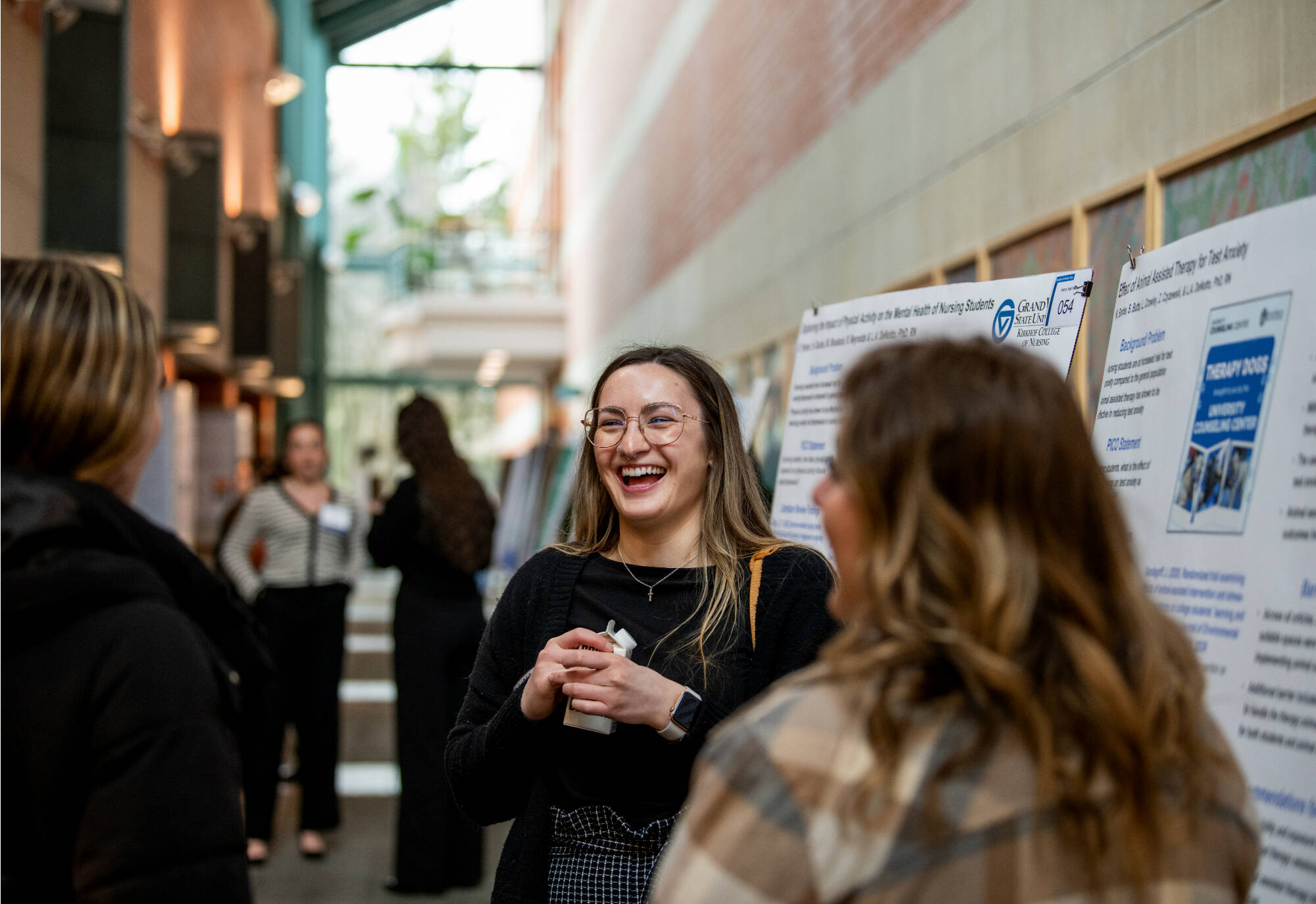 Elizabeth Crowley, center, a junior nursing student, gives a poster presentation of their research during Student Scholars Day April 9.   (Photo release on file)